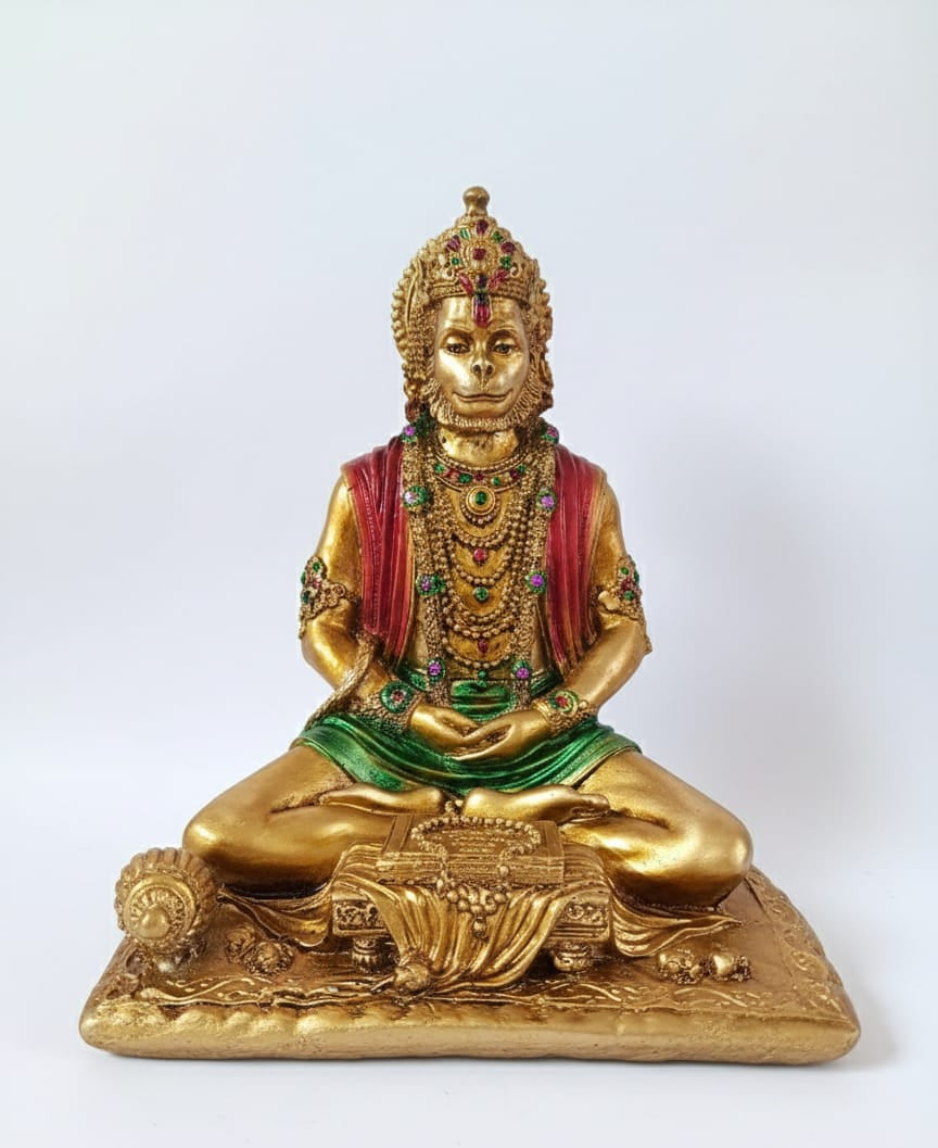 Gold-colored statue of a seated figure with jewelry on a white background