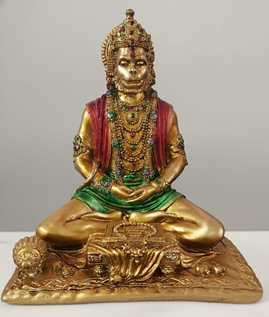 Decorative statue of a seated figure with gold finish and colorful attire on a white background