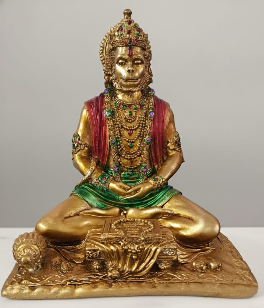 Decorative statue of a seated figure with gold finish and colorful attire on a white background